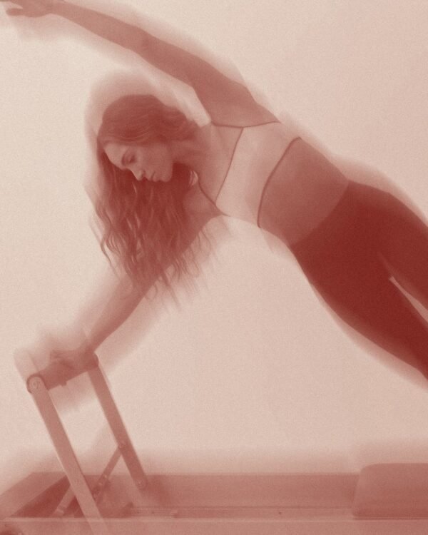 Mujer entrenando reformer pilates en la clase FRRM de KNND